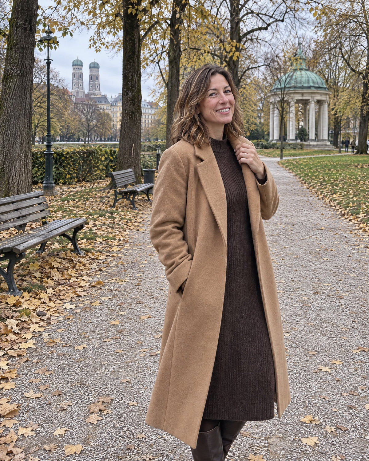 Frau im langen kamelfarbenen Wollmantel in einem herbstlichen Park